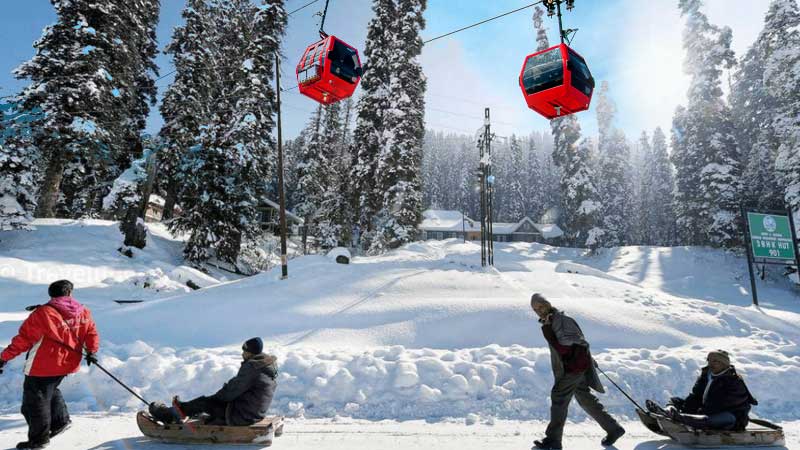 The famous Gulmarg Gondola cable car moving over snow-covered pine trees and mountains in Kashmir